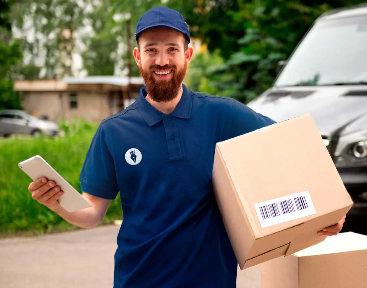 A imagem mostra um entregador sorridente com uniforme azul segurando caixas e um tablet, ilustrando a logística do e-commerce para o post "Contabilidade Especializada em Ecommerce".