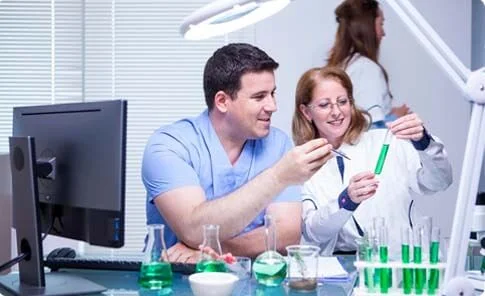Dois farmacêuticos examinando amostras em laboratório.