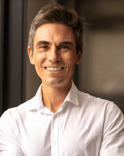 Founding Partner Guilherme Pagotto smiling, wearing a white formal t-shirt.